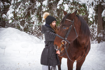 Fototapeta premium Young girl and horse in a winter forest