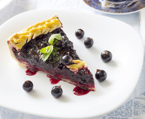 Homemade honeyberry pie in white plate on light cloth napkin