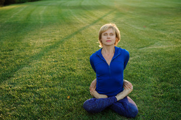 beautiful woman doing yoga exercises in park