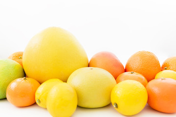 Fruit's background. Citrus fruits pattern made of lemon, orange, grapefruit, sweetie and pomelo on white background.