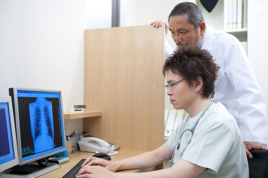 Two male doctors examining x-ray