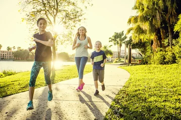 Fotobehang Family exercising and jogging together at the park © Brocreative