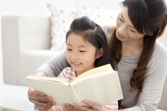 Mother and daughter reading a book together