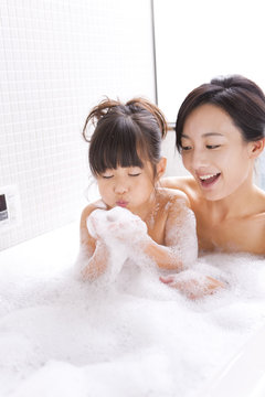 Mother and daughter in bubble bath