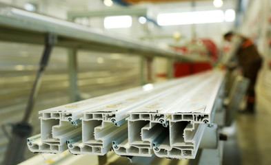 Manual worker assembling PVC doors and windows. Manufacturing jobs.. Factory for aluminum and PVC windows and doors production.