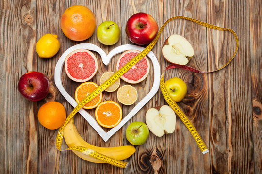Fruit Diet, centimeter and a heart on  wooden background