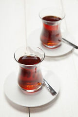 Two cups of tea on a white wooden background
