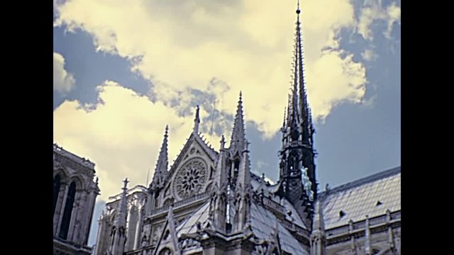 Notre Dame Gothic cathedral in Paris, France in sunny blue cloudy sky. Our Lady of Paris church. Historic restored footage on 1976 with no people. Details close up.Popular tourist attraction in Paris.