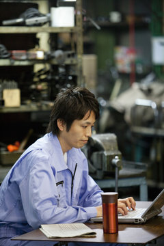 Male Factory Worker Using Laptop