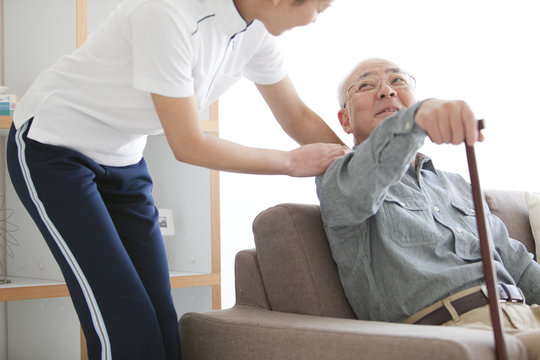Caregiver helping elderly man