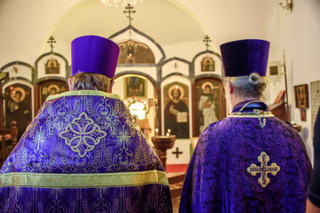 Backs of two priests celebrating the Feast of Orthodoxy on the first Sunday of Great Lent at the...