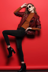 fashion model in sunglasses, beautiful young woman. leather jacket, studio shot