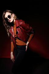 fashion model in sunglasses, beautiful young woman. leather jacket, studio shot