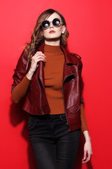 fashion model in sunglasses, beautiful young woman. leather jacket, studio shot