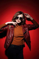 fashion model in sunglasses, beautiful young woman. leather jacket, studio shot