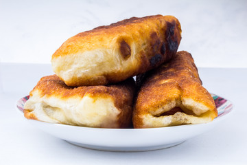 Homemade pasties in plate isolated on white background. traditional Russian patty