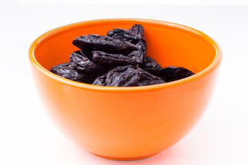 prunes on a plate on white background