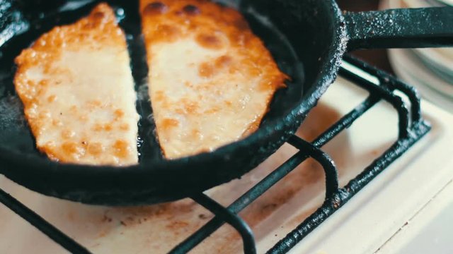 Housewife roasts chebureks in pan - Georgian national dish