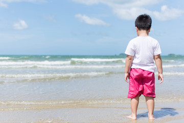 a boy standing on the beach