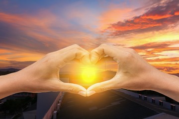 hand forming  a heart shape with  sunset  light and copy space for add text