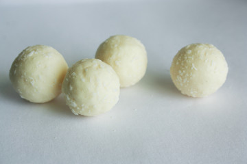 Fototapeta na wymiar white chocolate candy balls with coconut on white background