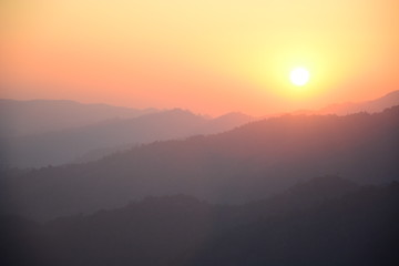 Blurred sunset silhouette  mountain landscape background with orange sky.