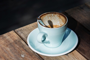 Empty coffee cup after drink on wood table,dramatic