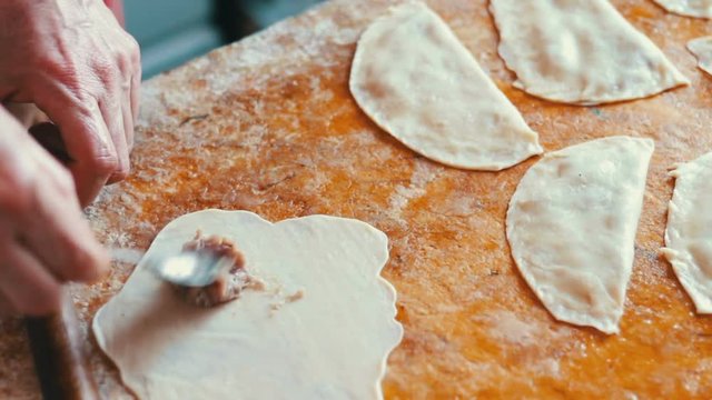 Housewife roasts chebureks in pan - Georgian national dish