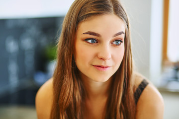 Young woman sitting near table in the kitchen