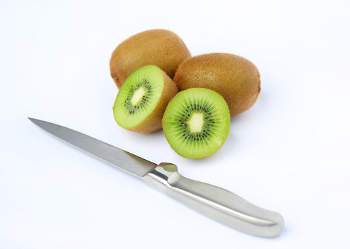 Half of juicy kiwi fruit with knife isolated on white background