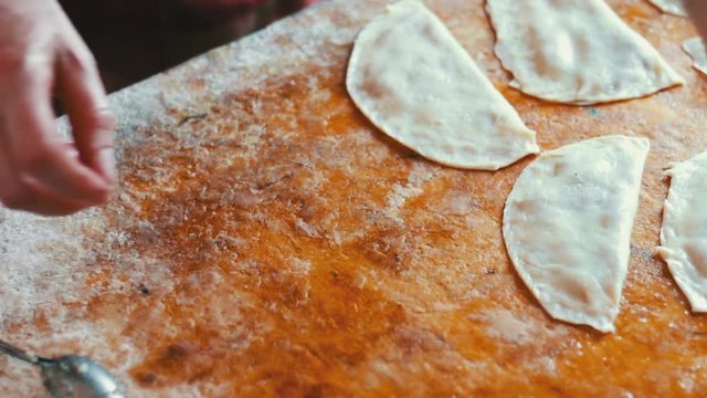 Housewife roasts chebureks in pan - Georgian national dish