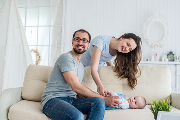 Obraz premium family with the baby on the sofa