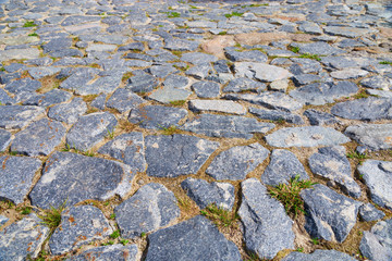 Stone floor. Large stone on the old road. Stone pavement from big cobblestone in perspective. Horizontal format.