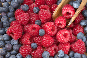Forest fresh raspberry and blueberry macro with a wooden shovel
