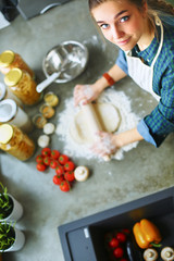 Beautiful woman cooking cake in kitchen standing near desk