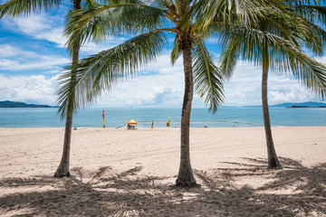 People enjoying a swim on tropical beach, The Strand, Townsville, Australia while a lifeguard keeps watch