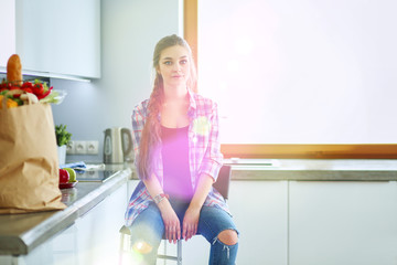 Obraz premium Beautiful woman cooking cake in kitchen standing near desk
