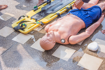 dummy drowning training long spinal board and pocket mask on the floor near pool