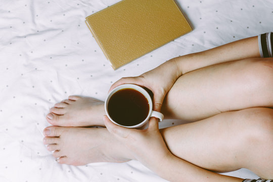 Woman on the bed with cup of coffee