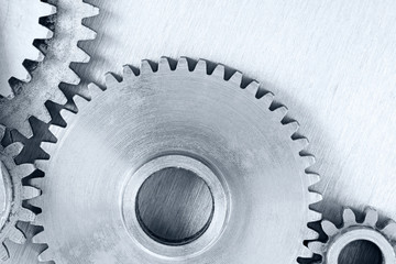 set of different metal cogwheels on scratched background for industrial concept closeup