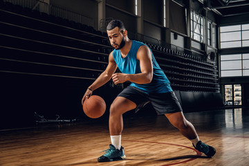 Professional basketball player in an action in basketball field.