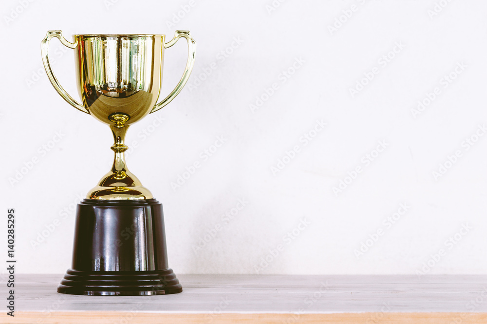 Wall mural golden trophy on wooden table with copy space