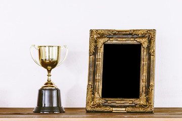 Golden trophy on wooden table with copy space