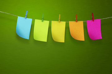 Sticky notes hanging by clothespin with light green background