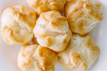 Cream puffs with vanilla custard on wooden table
