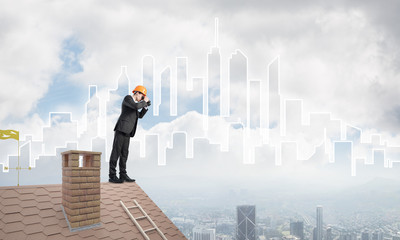 Engineer man standing on roof and looking in binoculars. Mixed media