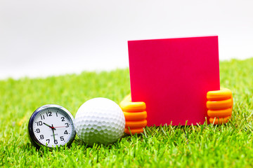 Naklejka premium Time for golf. Golf ball with clock are on green grass