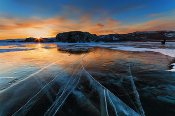 People on the frozen lake watching the sunset. Baikal, Russia.