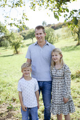 happy father with 2 children outdoors