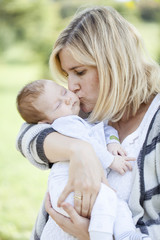 young mother with newborn baby outdoors